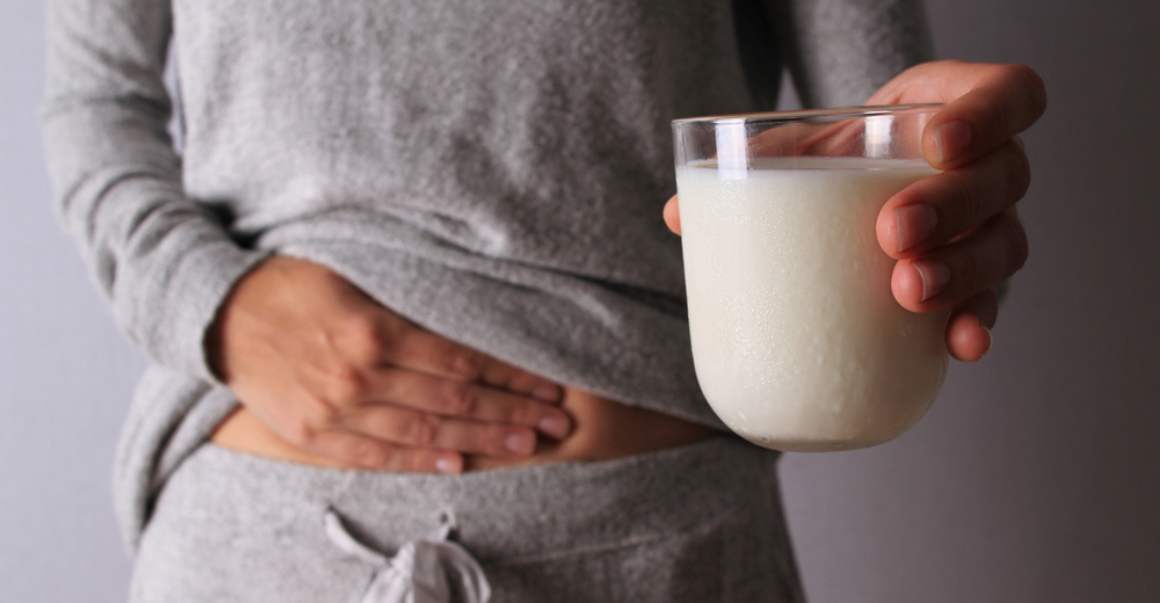 Meisje dat melk drinkt heeft pijn door lactose-intolerantie